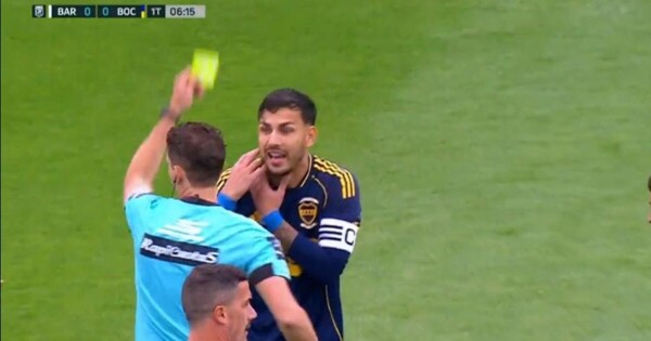 Футболист получает желтую карточку в напряженном матче